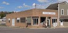 One-story brick building with rounded corners, probably dating from the 1940s or early 1950s; "Viking Lumber" sign with profile head of Viking