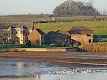 Stone buildings with water in front.