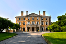 Single facade of a three-story beige Renaissance Revival mansion