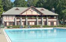 An outdoor pool and two-story building with a large pediment