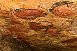 Rock painting of a bison in red and black.