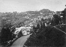 A hillside with houses having tiled roofs.