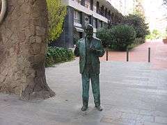 Life-sized statue of a man standing with his hands extended