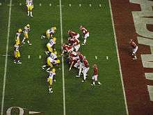 American football players prior to running a play.