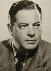 Sepia tone portrait photo of a white man wearing a jacket and tie