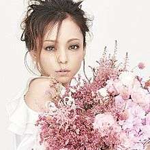 A woman in a white dress in front of a pink bouquet