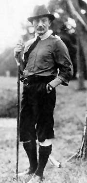 black and white photograph of a man standing outdoors, facing the camera