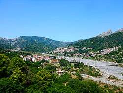 Wooded, mountainous township under a blue sky