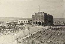 Large building, with wide road and field in front