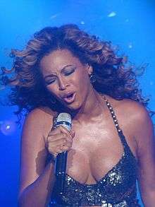 An Afro-American woman holding a microphone.