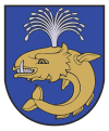 A coat of arms depicting a sea creature with sharp teeth, one protruding bottom tooth, and a blowhole spewing water