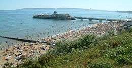  photograph of a crowded Bournemouth beach, near Bournemouth pier, on a hot summer's day