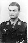 A man wearing a military uniform with an Iron Cross displayed at the front of his uniform collar.