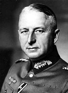 Black-and-white portrait of an older man wearing a military uniform, his hair is combed back.