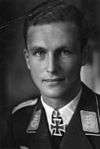 A man wearing a military uniform with an Iron Cross displayed at the front of his uniform collar.