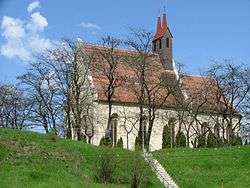 A stone church with a small tower on a hill