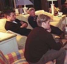  Bill Clinton, Ben Affleck and Matt Damon sit on two sofas while looking towards a television screen