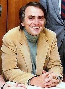 Photograph of a man sitting at a table.