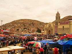 A crowd gathered in front of the Sanctuary of the Virgin of Socavón.