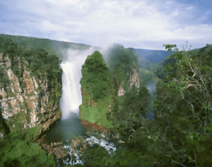 Large waterfall among rocks covered with vegetation.