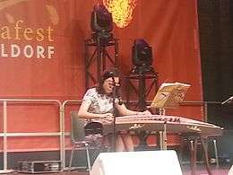 Seated woman playing a guzheng