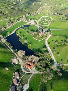 Aerial photograph of an estate with a racetrack visible in the background