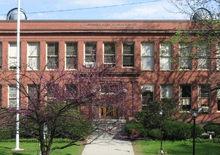 Red-two-story building with spring-flowering tree in front