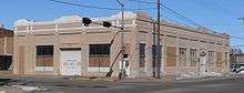 One-story building on street corner with garage entrances on south and east sides