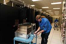 A Cray technician upgrading a stack of compute blades.