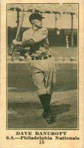 A sepia-toned baseball card of a player swinging his bat at a pitch.