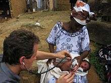 Dr. McCullough treating an infant with an infection in Ghana, Africa while creating KaeMe.