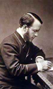 An old photograph of a man, wearing spectacles, writing at a desk.