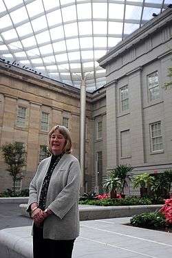 Elizabeth Broun standing in the covered courtyard of the museum