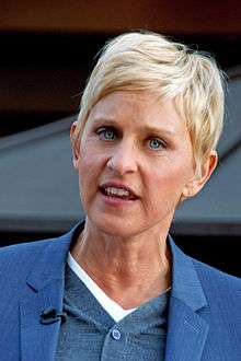 Headshot of a blond haired female in her early fifties wearing a blue jacket over blue and white shirts.