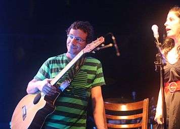 A man with a guitar and a woman with a microphone