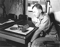 Unidentified officer examining the propeller from the torpedo that penetrated the bow of the Chaffee without exploding. The propeller is broken and sitting on a table.