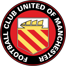 A circular badge with "Football Club United of Manchester" written in white capitals just inside the black circumference with a red trim. Inside is a yellow crest on a red background. The crest has a yellow ship with three sails on a white background, and three yellow stripes on a red background.