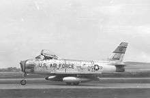 A jet is seen perpendicular to the camera while parked on the ground