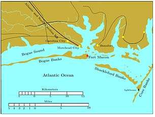 Bogue Banks is a long, narrow island extending from the left edge to past the middle of the chart. Fort Macon is at its eastern end. About two miles to the southeast is the western end of Shackleford Banks, which extends to the east southeast about seven miles. It is separated by a narrow inlet from Core Banks, which extends off the chart to the northeast. Behind these banks are the sounds, ranging in width from one to five miles. Carolina City, Morehead City, and Beaufort are sited on the sounds, all within 10 miles of Fort Macon. The Atlantic and North Carolina Railroad begins in Morehead City and runs off the map to the northwest.