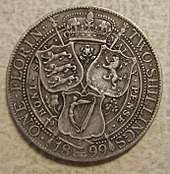 a silver coin, with three shields on it.