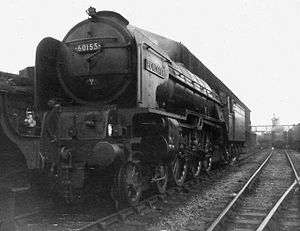 Steam locomotive with four small carrying wheels at the front, six large driving wheels, two small carrying wheels below the cab, and a tender