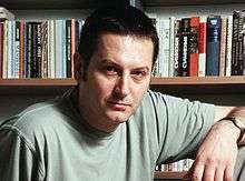 Author Georgi Gospodinov in front of a bookcase, circa 2005