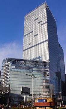 Ground-level view of a glass, rectangular high-rise