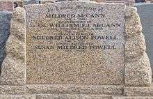 a colour photograph of a brown granite or marble headstone