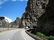 A pair of bridges leading to a pair of tunnels at the canyon wall