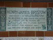 A tablet formed of six standard sized tiles, bordered by green flowers in the style of the Arts and Crafts movement