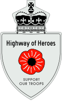 A Highway of Heroes reassurance marker with a red poppy flower in place of a number. Above that is the text Highway of Heroes, and below it SUPPORT OUR TROOPS.