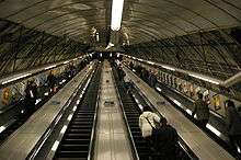 View up the inclined main escalator shaft with four escalators in a line carrying passengers up and down.