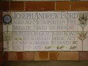 A tablet formed of five tiles of varying sizes, bordered by yellow and blue flowers in an art nouveau style