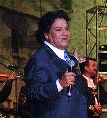 A man with a blue jacket holding a microphone.